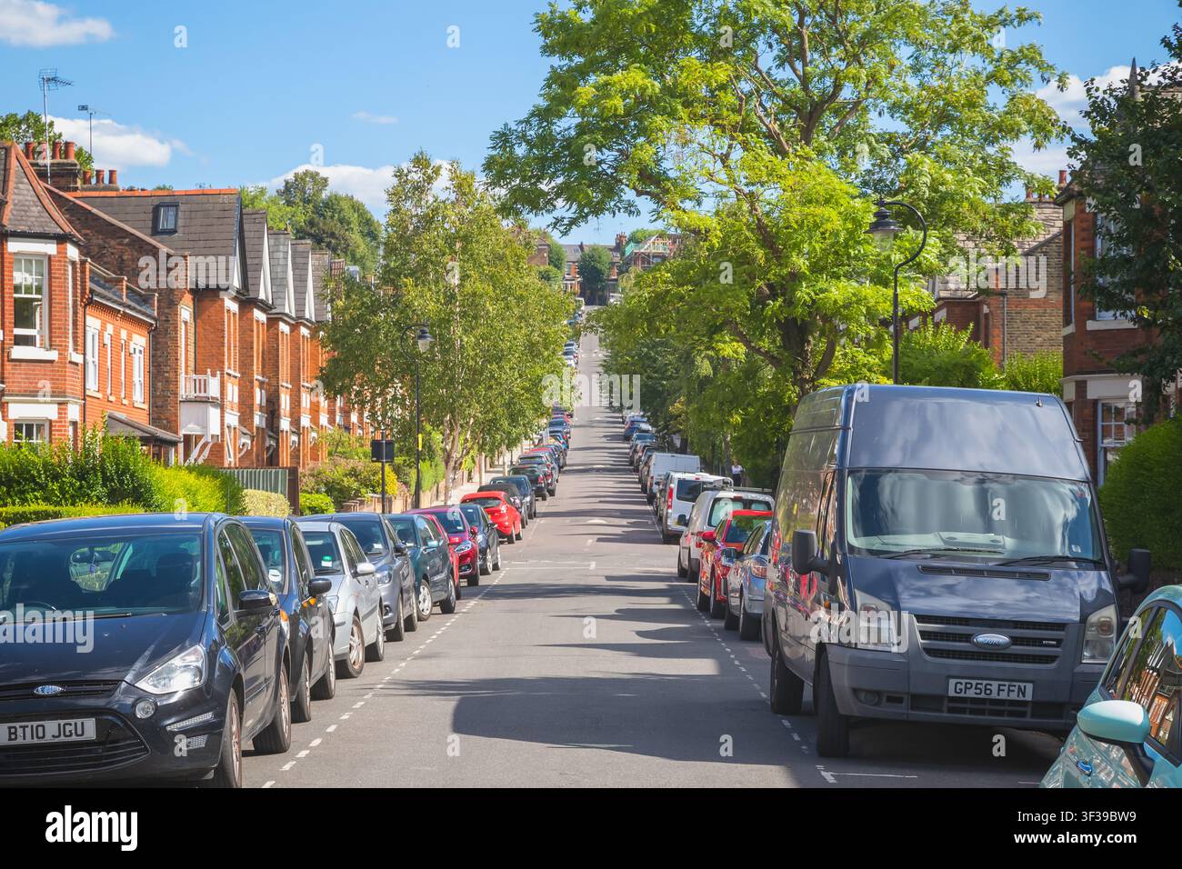 Londra, Regno Unito – 20 luglio 2026 – Una strada in salita di case a schiera con auto parcheggiate nella zona riservata ai residenti intorno a Crouch End, nord di Londra Foto Stock
