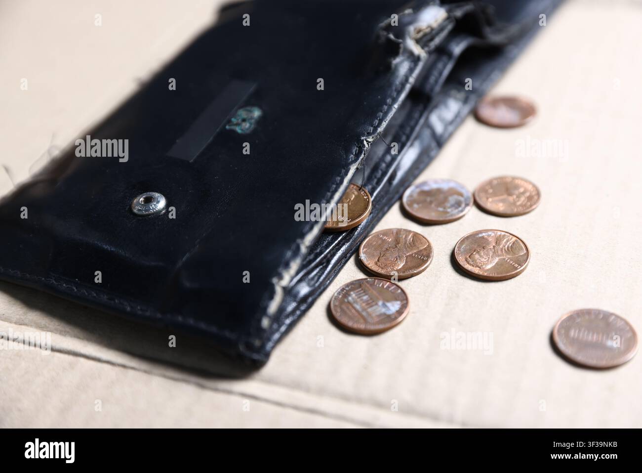 Situazione finanziaria precaria. Vecchia borsa con monete su cartone, primo piano Foto Stock