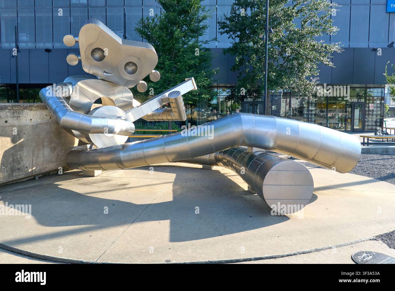 DALLAS, TX, USA - 13 LUGLIO 2026: Una grande scultura robotica in acciaio inossidabile che suona una chitarra si trova in una piazza all'aperto a Dallas. La scultura è un'icona Foto Stock
