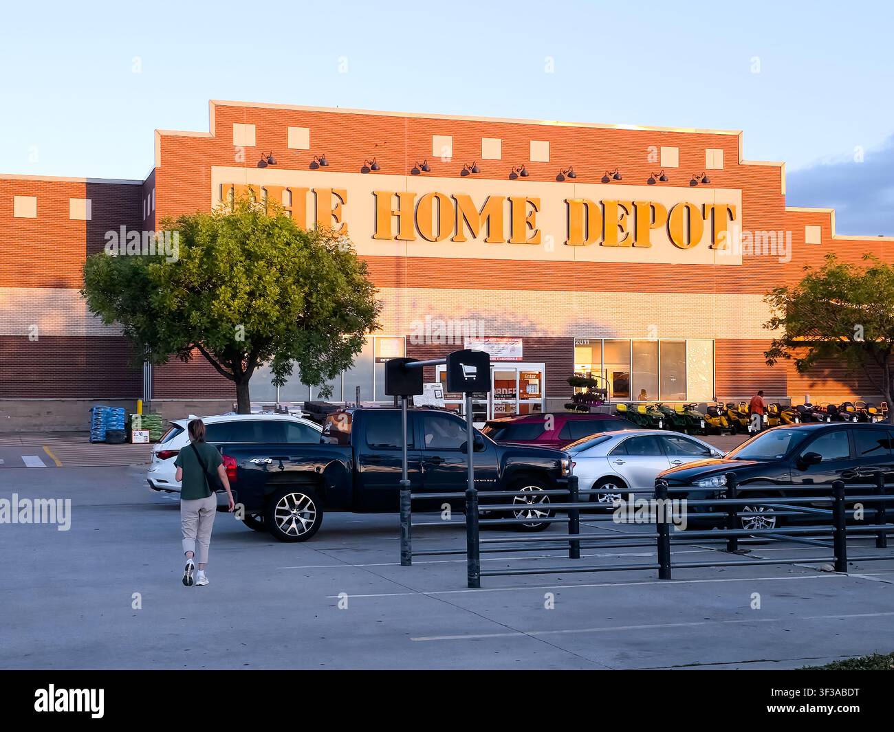 DALLAS - 15 LUGLIO 2026: Una persona attraversa il parcheggio dirigendosi verso il negozio The Home Depot. The Home Depot è un noto rivenditore di articoli per il fai-da-te Foto Stock