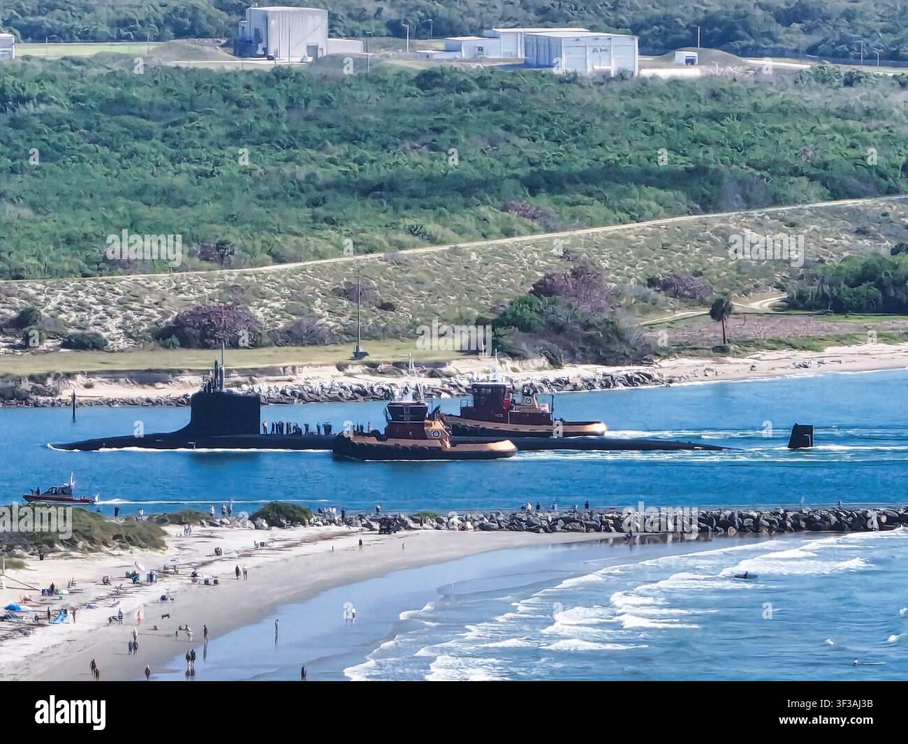 Sottomarino d'attacco della marina statunitense scortato da rimorchiatori nel porto di Port Canaveral Foto Stock