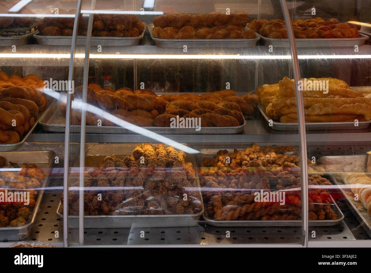 Vetrina da forno piena di pasticcini freschi, ciambelle e prodotti da forno Foto Stock