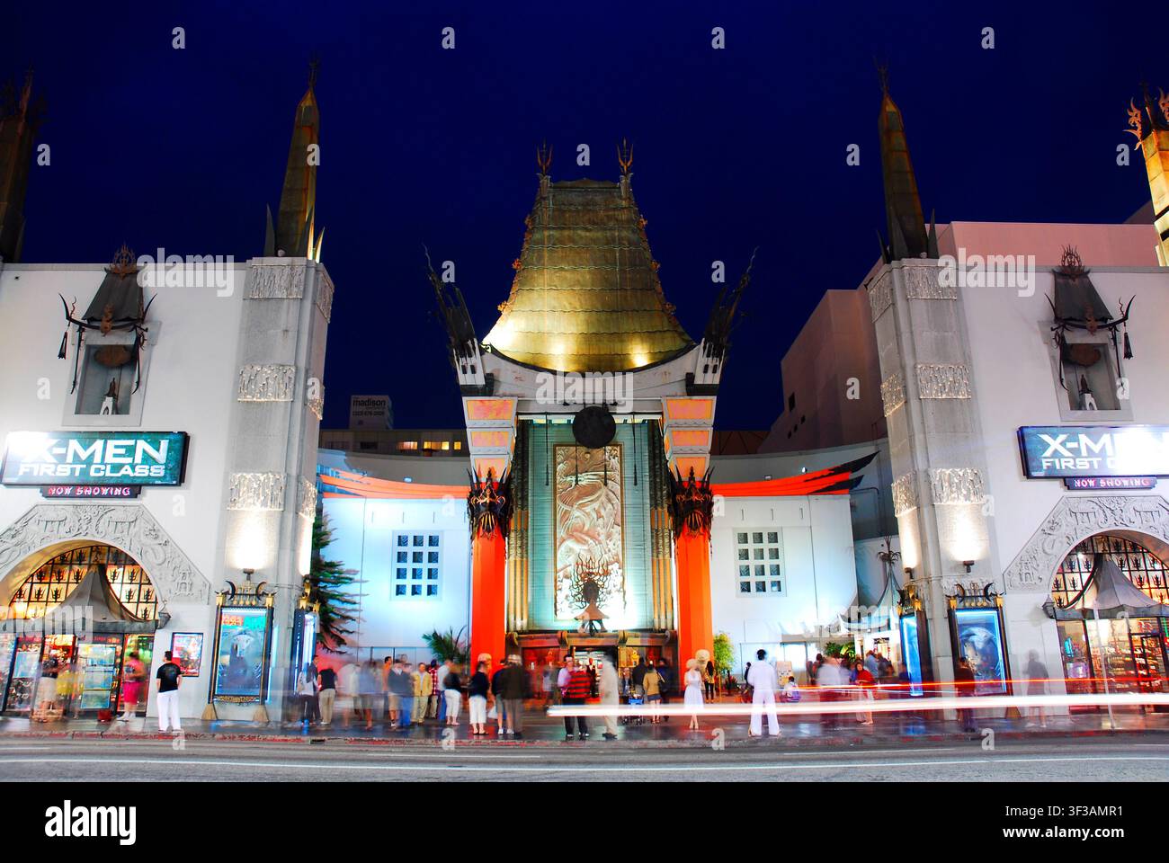 Di notte, le persone camminano intorno al Graumann Chinese Theatre illuminato, osservando le impronte delle star del cinema a Hollywood, in California, vicino a Los Angeles Foto Stock