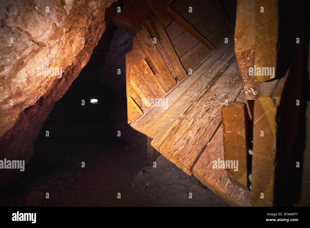 Struttura di supporto in legno in un pozzo di miniera storico con pareti rocciose strutturate Foto Stock