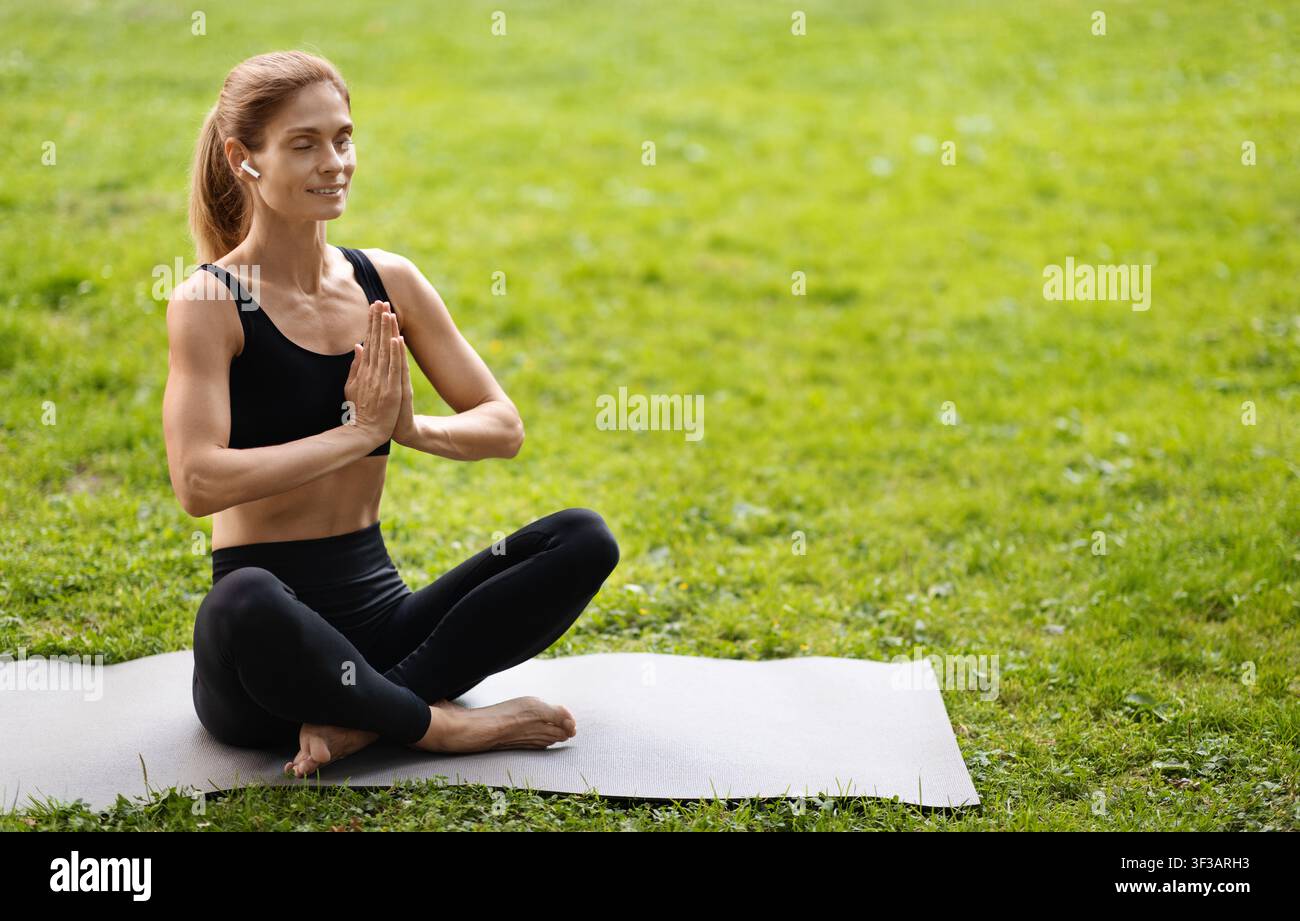 Donna yoga di mezza età che pratica all'aperto, spazio copia Foto Stock