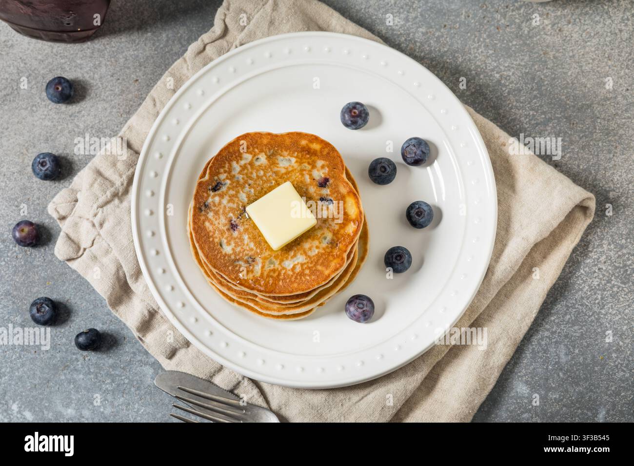 Dolce impilata di pancake fatti in casa con mirtilli, burro e sciroppo d'acero Foto Stock