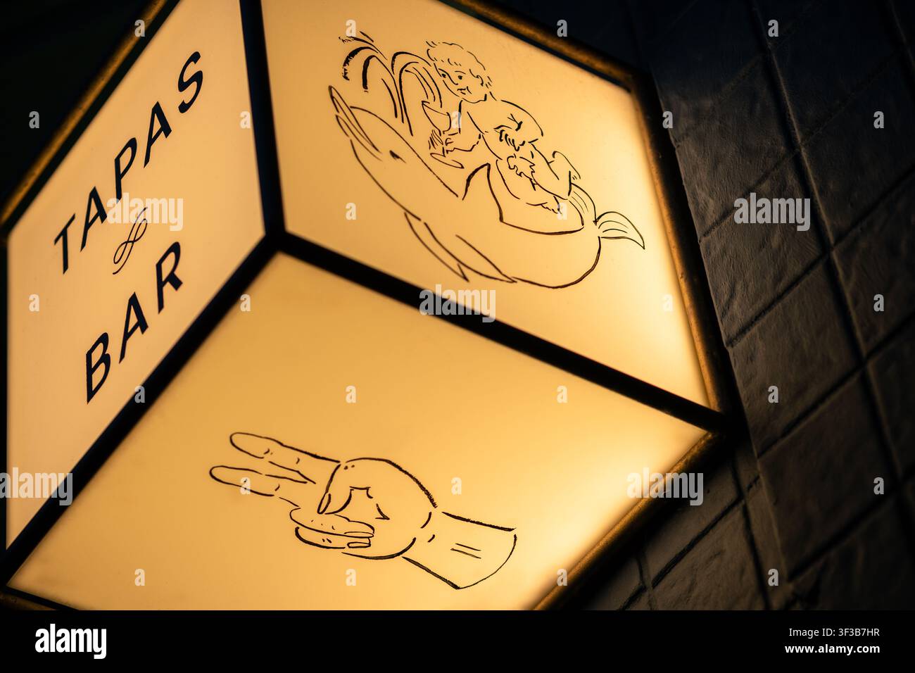 Insegna a cubo illuminata per un bar di tapas con disegni a linea su Commercial Drive a Vancouver, British Columbia. Foto Stock