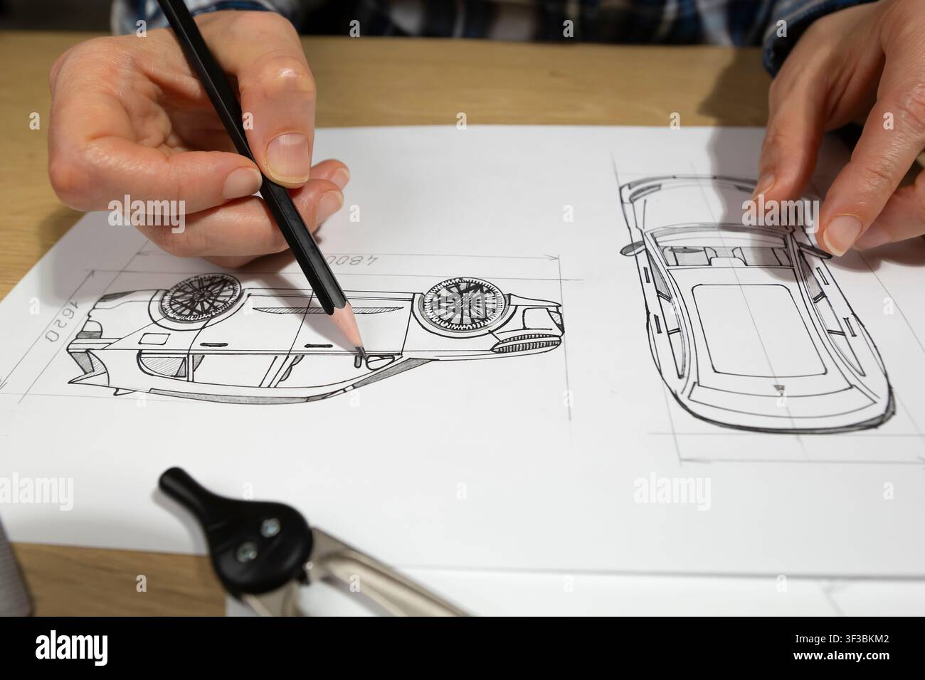 Mani di un ingegnere che disegna un prototipo di veicolo automobilistico con la matita su carta alla scrivania. Progettista industriale che sviluppa nuove bozze di progetti di auto vicino a me Foto Stock