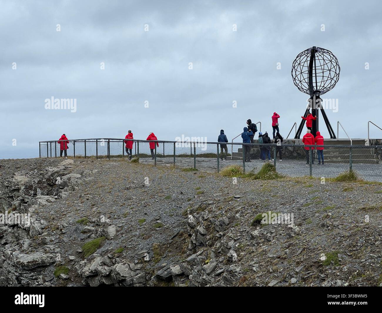 Visitatori all'iconico monumento del Globo a Nordkapp, in Norvegia, che si affacciano sull'Oceano Artico al capo più settentrionale d'Europa - Immagine stock catturata con smartphone