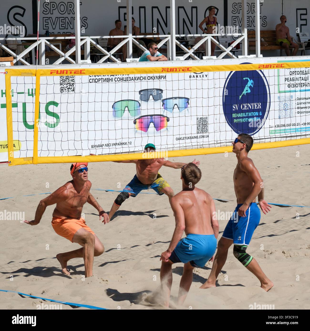 KIEV, UCRAINA - 18 luglio 2026: I giocatori di beach volley osservano la palla che scende e aggiustano le loro posizioni durante una partita amatoriale di beach volley all'aperto Foto Stock
