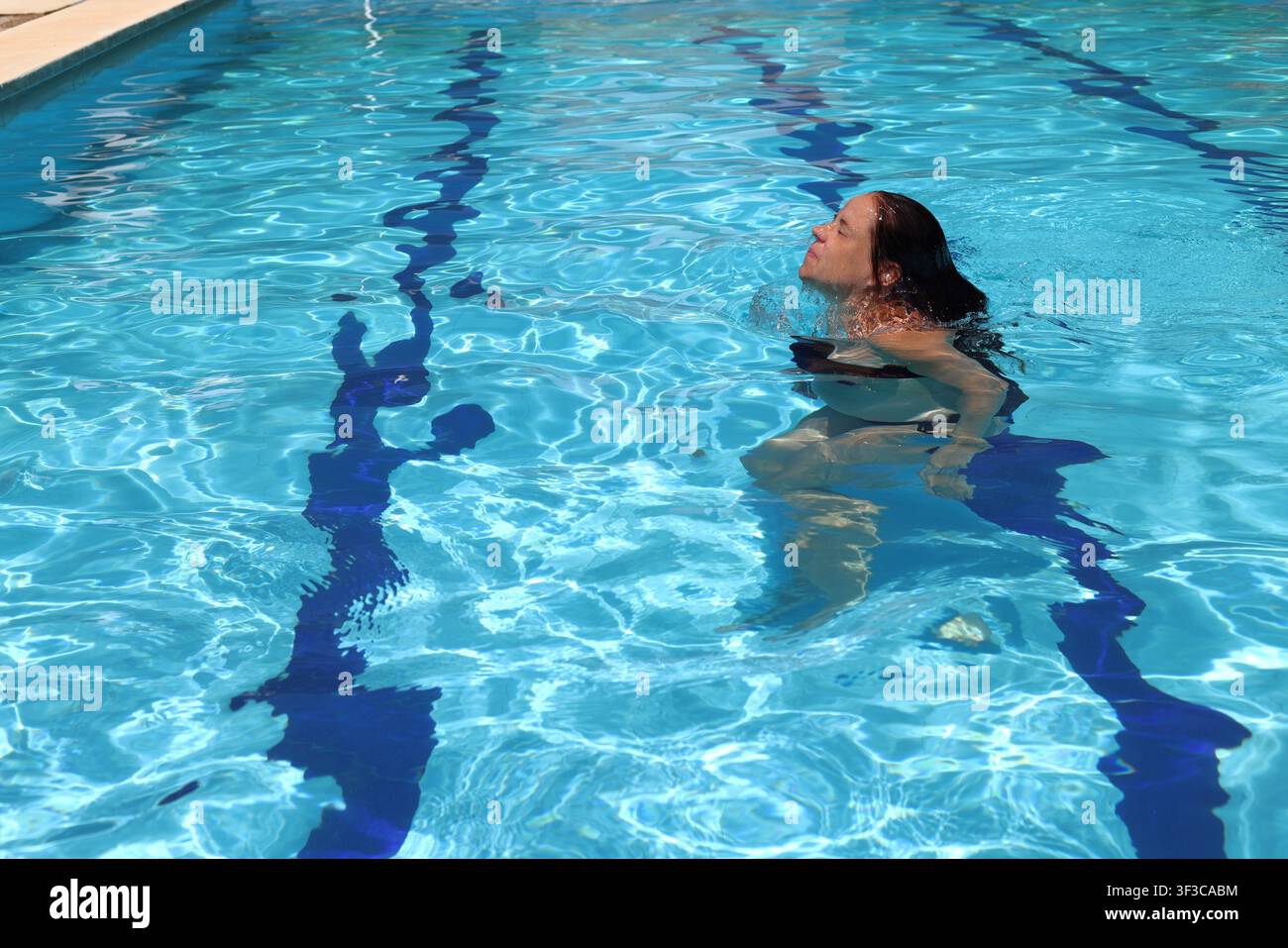 Una madre in attesa che pratica esercizi a basso impatto in una piscina Foto Stock
