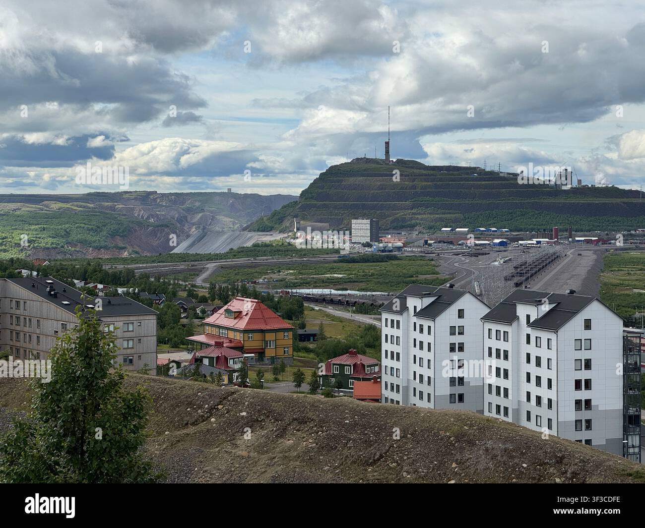 Vista di Kiruna, Svezia, che mostra la miniera di ferro, il paesaggio urbano e l'area mineraria terrazzata sotto un cielo nuvoloso. - Immagine stock catturata con smartphone