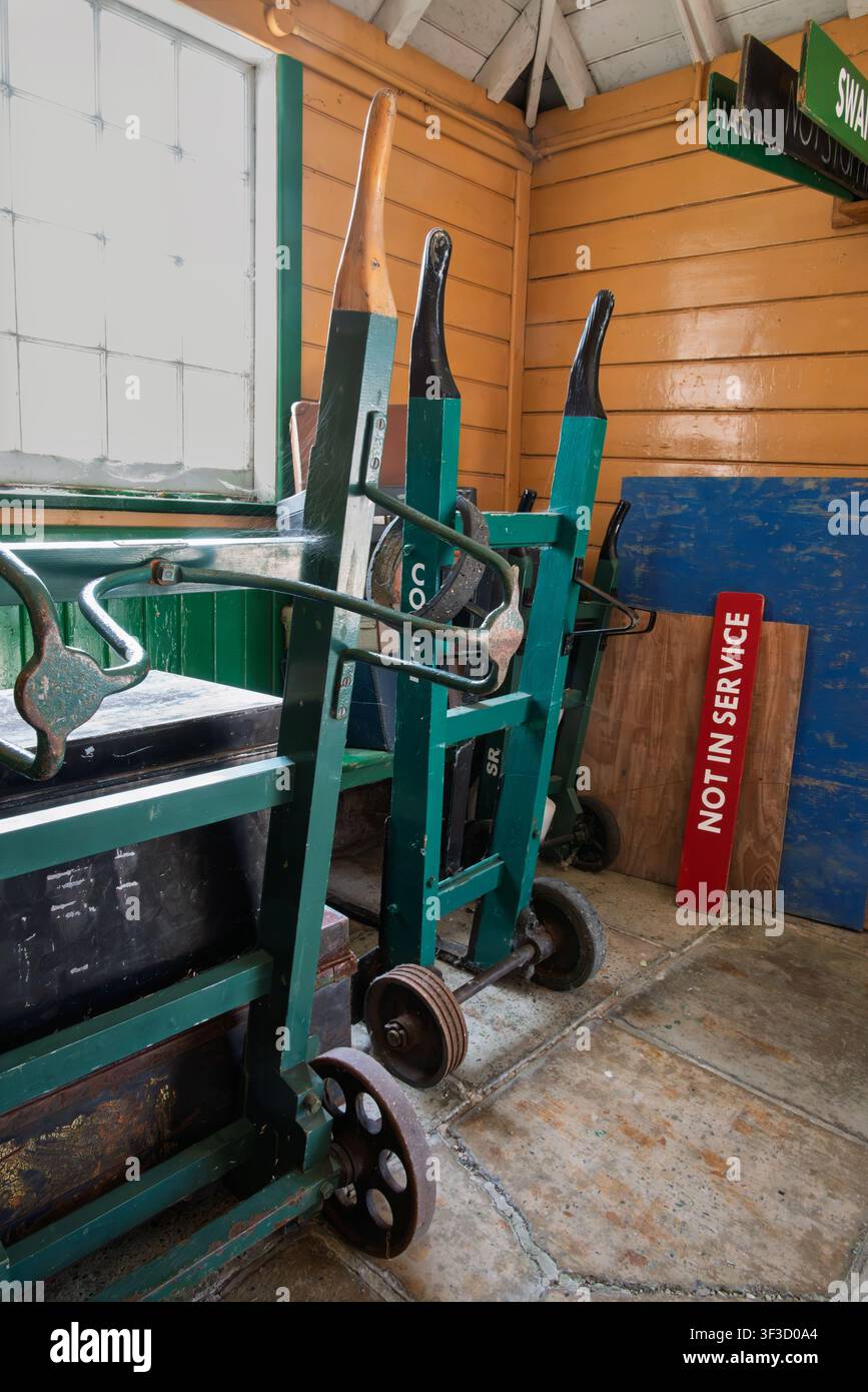Norden, Inghilterra, 18 luglio 2026. Carrelli a mano ferroviari verdi e un cartello "Fuori servizio" all'interno di una stanza di legno. Cartelli per Swanage e "Non fermarsi" visibili. Sw Foto Stock