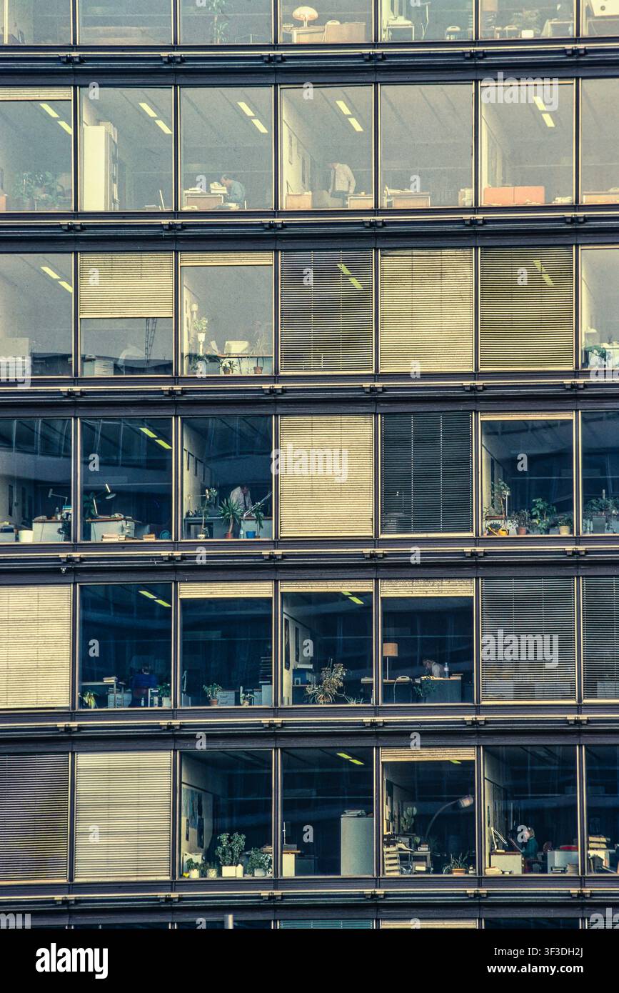 Facciata di un moderno edificio per uffici con file simmetriche di finestre in vetro che rivelano gli spazi di lavoro interni. Bruxelles, Belgio, Europa. Foto Stock
