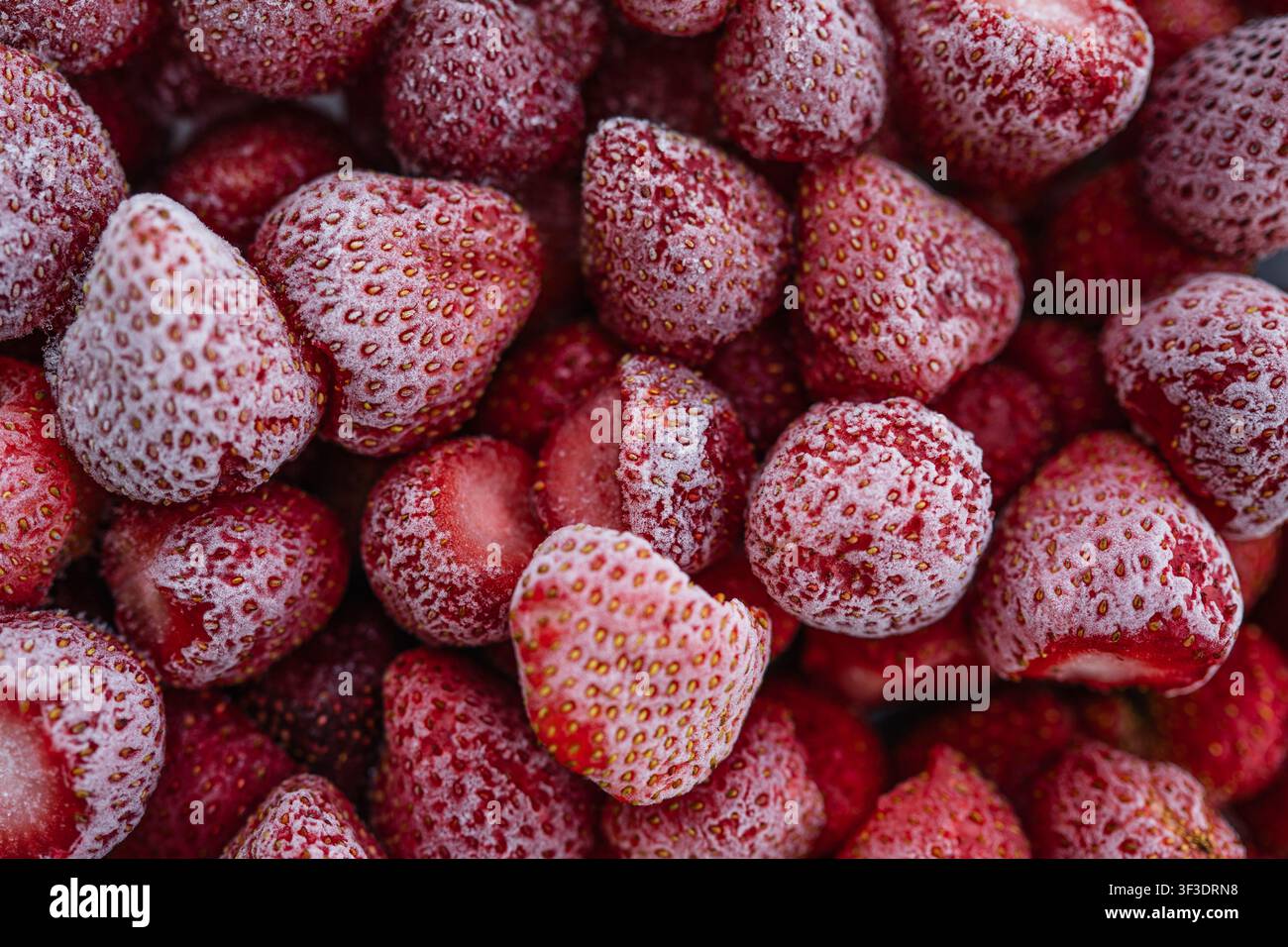 Fragole congelate sfondo a distanza ravvicinata con cristalli di ghiaccio e texture naturale Foto Stock