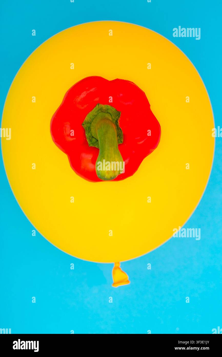 La parte superiore di un peperone rosso dolce su un palloncino giallo, per decorazione, per il design di testo, per modelli. Foto Stock