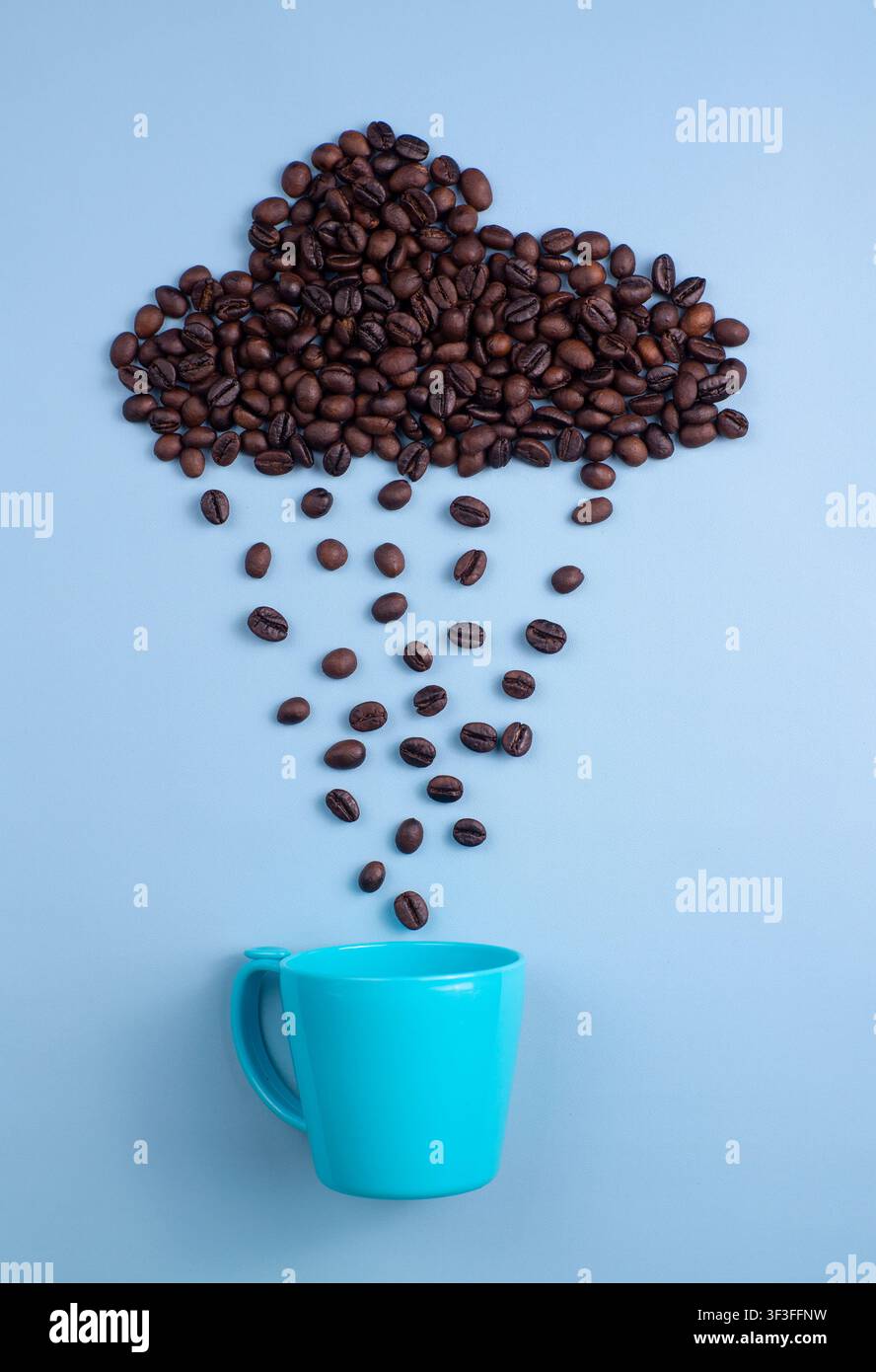 Nuvola di pioggia di chicchi di caffè che cade in una tazza blu su sfondo blu Foto Stock