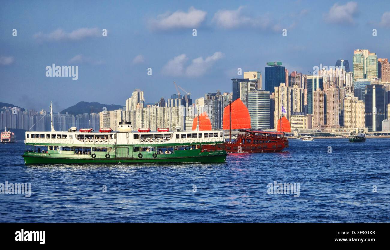 La Star Ferry e la giunca Aqualuna che navigano nel Victoria Harbour a Hong Kong. Foto Stock