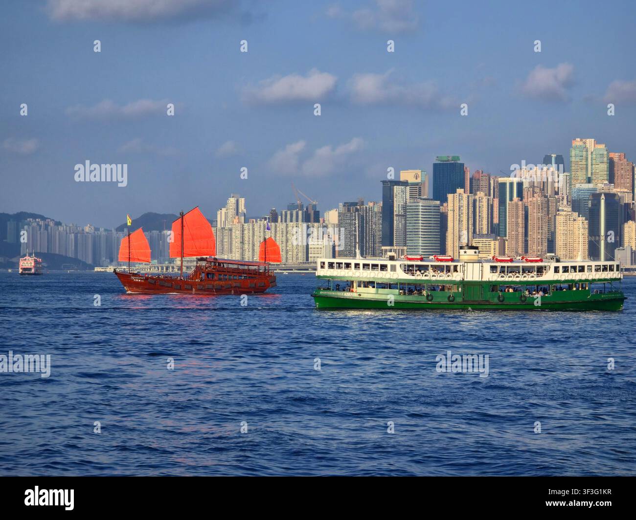 La Star Ferry e la giunca Aqualuna che navigano nel Victoria Harbour a Hong Kong. Foto Stock