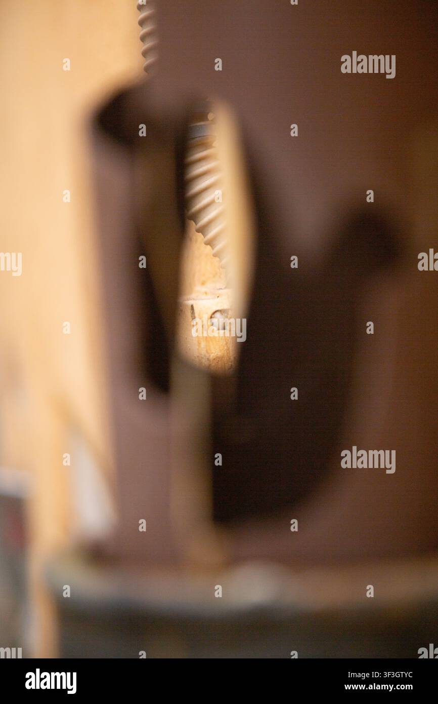 primo piano di metallo in un ambiente interno con atmosfera neutra e parti industriali visibili sullo sfondo. È marrone e grigio con un aspetto pulito e dettagliato Foto Stock