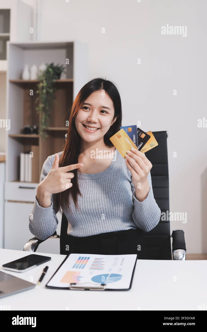 Giovane donna imprenditrice asiatica che utilizza smartphone e carta di credito per gli acquisti online. Pagamento online. Foto Stock