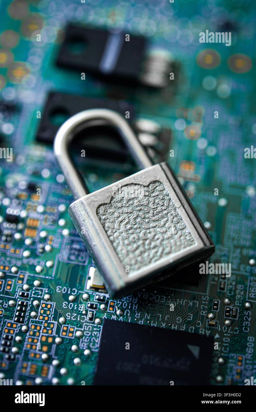 Lucchetto argentato aperto su una scheda elettronica, simbolizzante la cybersecurity, la privacy dei dati, l'accesso digitale e la tecnologia vulnerabile Foto Stock