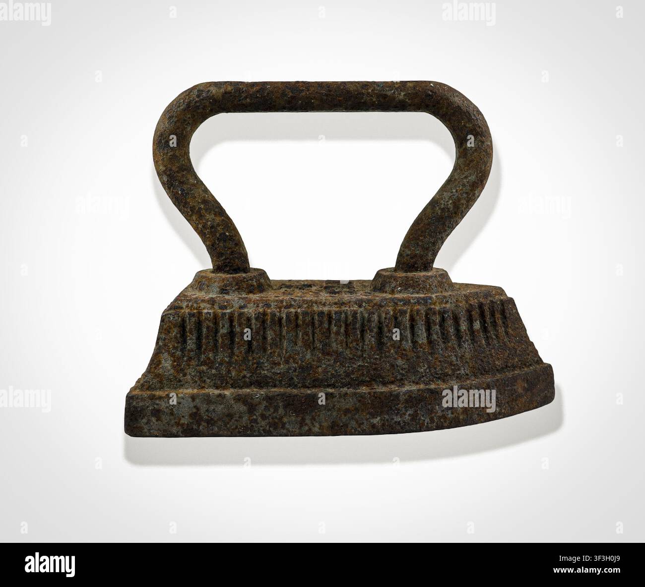 Questo ferro da stiro in ghisa risale al secolo scorso, evidenziando il design intricato e la durata degli strumenti domestici antichi usati per stirare i tessuti Foto Stock