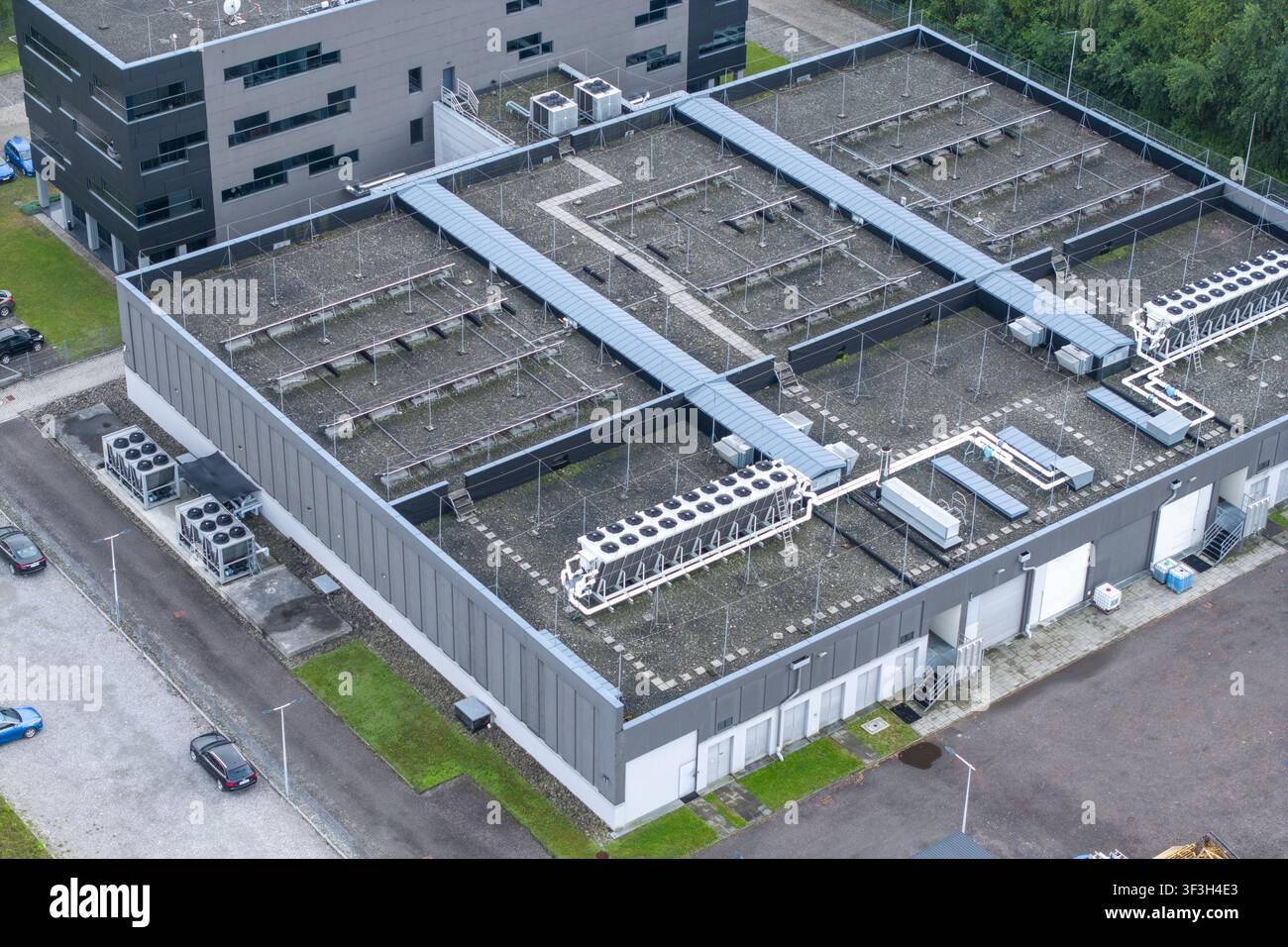 Vista aerea di un edificio ufficio di un centro dati AI con un grande sistema di raffreddamento HVAC installato sul tetto piano a Cracovia, Voivodato della Piccola Polonia, Po Foto Stock