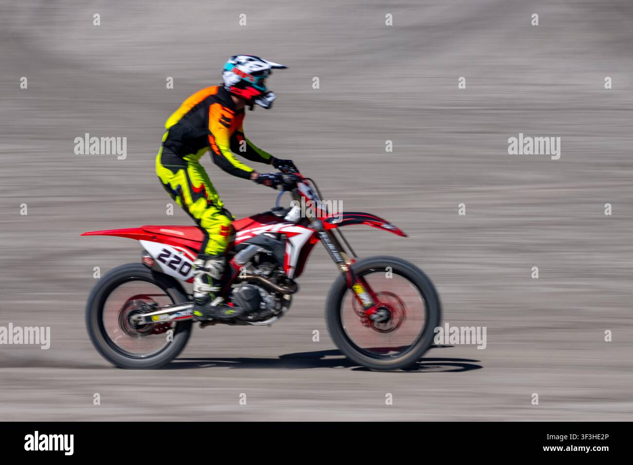 Un pilota su una moto da fuoristrada nell'area OHV di Swing Arm City, Caineville, Utah Foto Stock