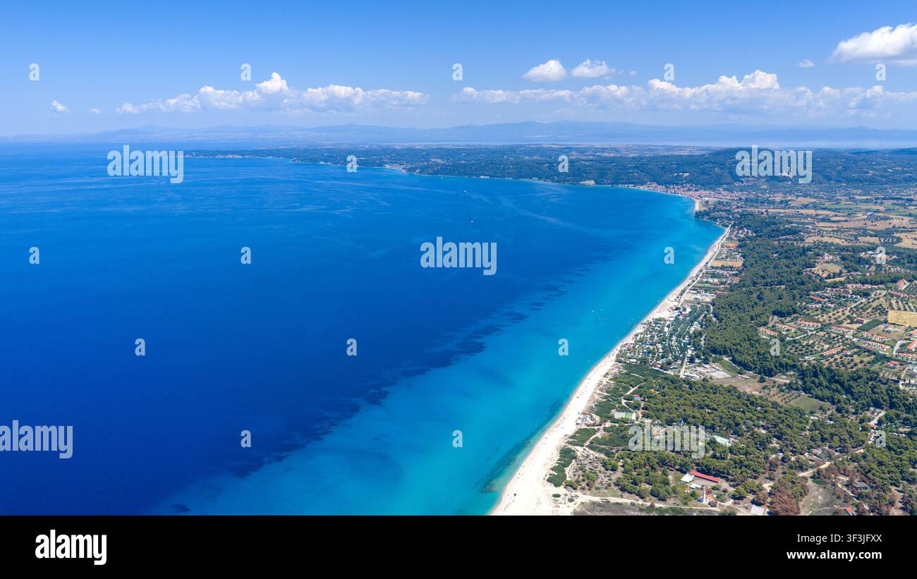 Spiaggia di Possidi, Grecia 11 luglio 2026. Foto aerea della spiaggia di Possidi e del paesaggio costiero circostante con acque turchesi e nuvole sparse sotto un cielo blu Foto Stock