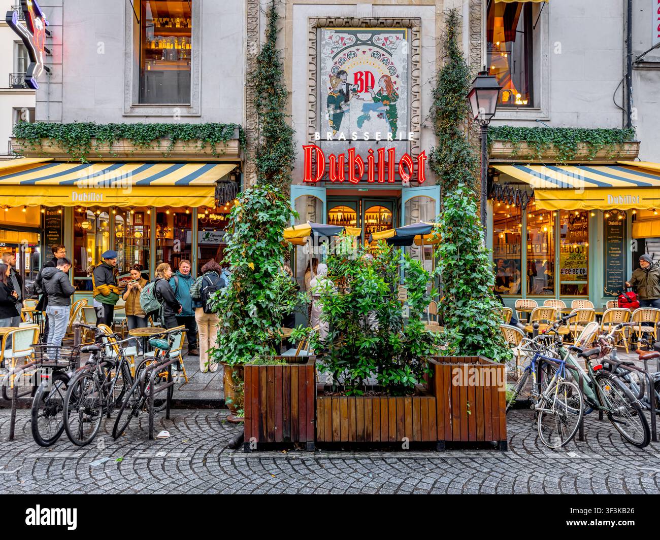 Persone in fila fuori dalla Brasserie Dubillot, una popolare brasserie francese situata al 222 Rue Saint-Denis, nel quartiere Sentier di Parigi, Francia Foto Stock