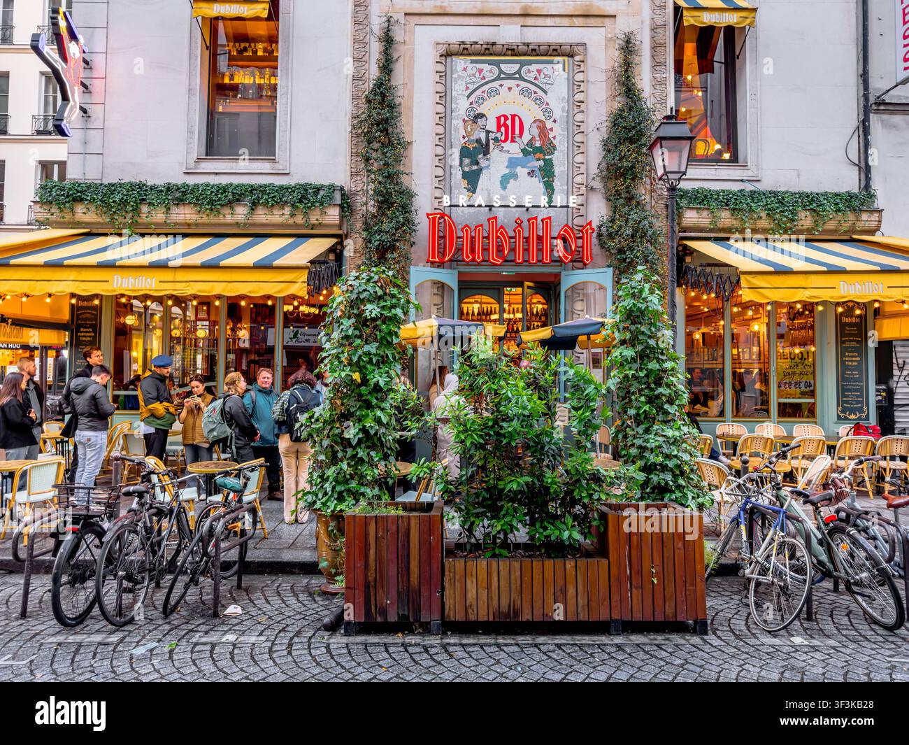 Persone in fila fuori dalla Brasserie Dubillot, una popolare brasserie francese situata al 222 Rue Saint-Denis, nel quartiere Sentier di Parigi, Francia Foto Stock