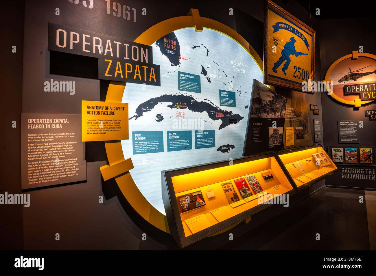 Esposizione della Baia dei Maiali al Museo Internazionale della Spionaggio | WASHINGTON D.C., Stati Uniti — Una mappa di Cuba e della Florida costituisce l’ancora della mostra “Operazione Zapata” al Museo Internazionale della Spionaggio, che ripercorre lo sbarco fallito del 1961 sostenuto dalla CIA alla Baia dei Maiali. La mostra espone i motivi del fallimento su quattro pannelli diretti — scarsa pianificazione, nessuna resistenza locale, sicurezza operativa debole e sostegno politico instabile — un caso di studio che il museo presenta come l’anatomia di un fallimento di azione segreta. Foto Stock