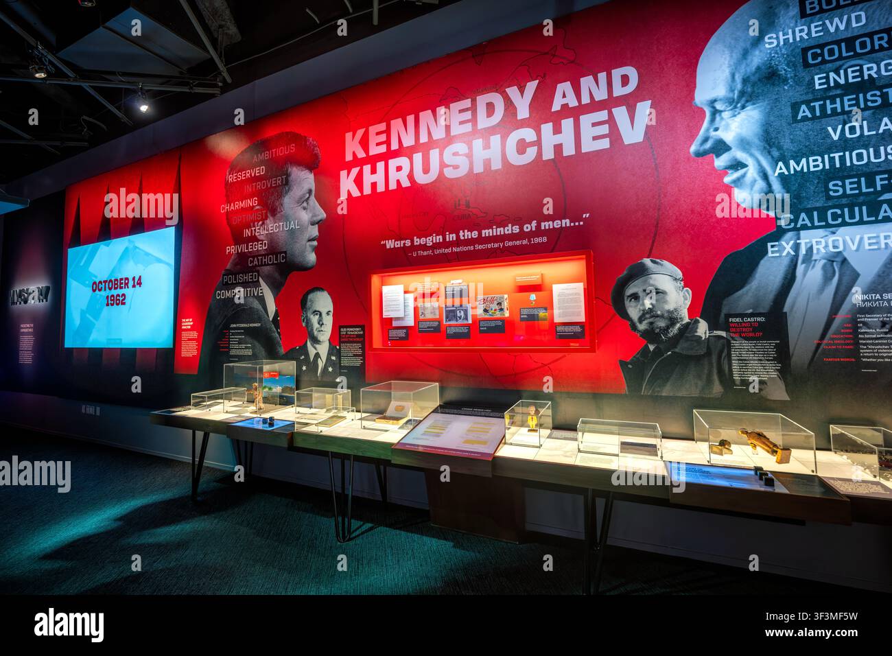 Esposizione di Kennedy e Chruščёv al Museo dello Spionaggio | WASHINGTON D.C., Stati Uniti — Una grafica delle dimensioni di un muro che associa John F. Kennedy e Nikita Chruščёv domina la galleria della crisi dei missili cubani al Museo Internazionale dello Spionaggio, datata 14 ottobre 1962 — il giorno in cui le foto di ricognizione statunitensi confermarono i missili sovietici a Cuba. Vetrine di vetro sottostanti contengono artefatti legati a Oleg Penkovskij, l’ufficiale dell’intelligence militare sovietica i cui rapporti segreti alla CIA e al MI6 aiutarono Kennedy a valutare le vere intenzioni di Chruščёv durante lo stallo. Foto Stock