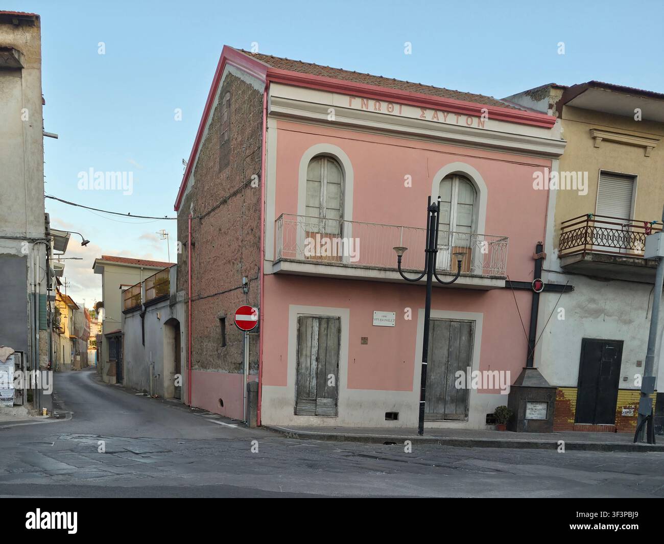 Edificio rosa storico a Frignano, Caserta, Italia, con il motto greco antico Conosci te stesso (ΓΝΩΘΙ ΣΑΥΤΟΝ) sulla facciata Foto Stock