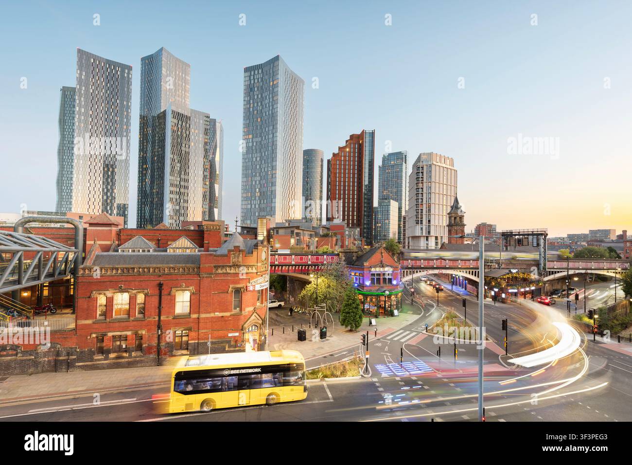 Una scena notturna di strada di Manchester, Regno Unito, che mostra edifici vecchi e nuovi. Foto Stock