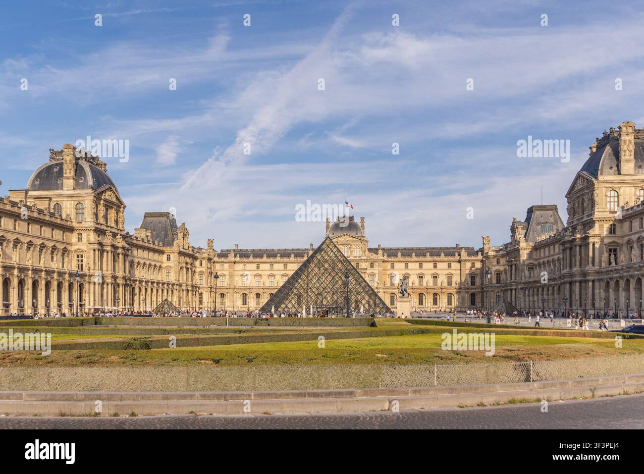 PARIGI, FRANCIA - 25 LUGLIO 2026: Iconica piramide di vetro e facciata storica del palazzo del Museo del Louvre Foto Stock