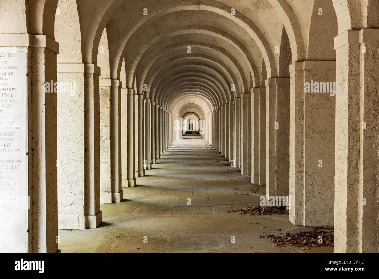 Francoforte, Germania - 15 maggio 2026: Lunga galleria storica ad arcade in pietra con archi simmetrici e targhe commemorative al cimitero Foto Stock