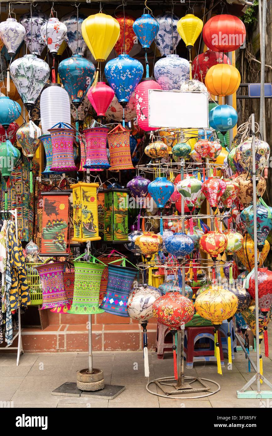 Una vivace esposizione di lanterne di seta artigianali appese a una bancarella del mercato nella vecchia città di Hoi An, Vietnam Foto Stock