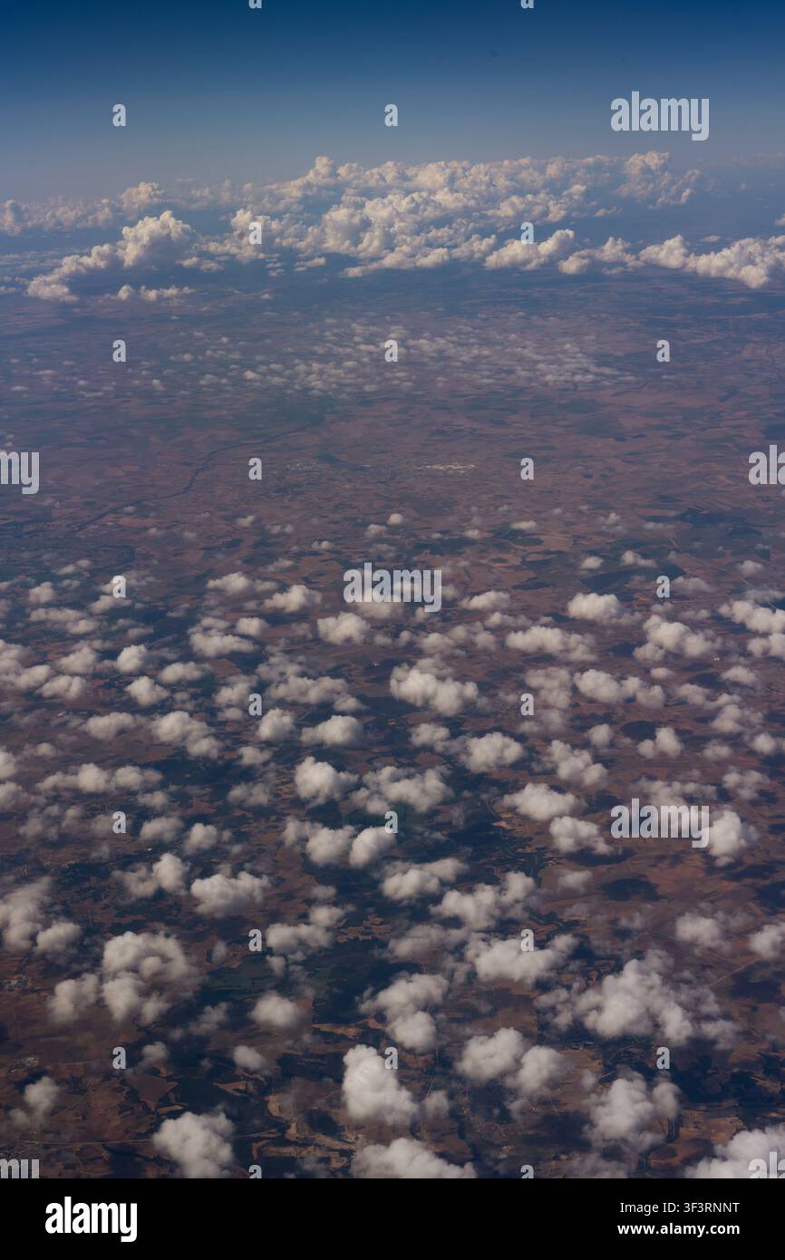 Prospettiva aerea di un cielo nuvoloso con soffici nuvole bianche sparse nell'ampiezza blu. Foto Stock