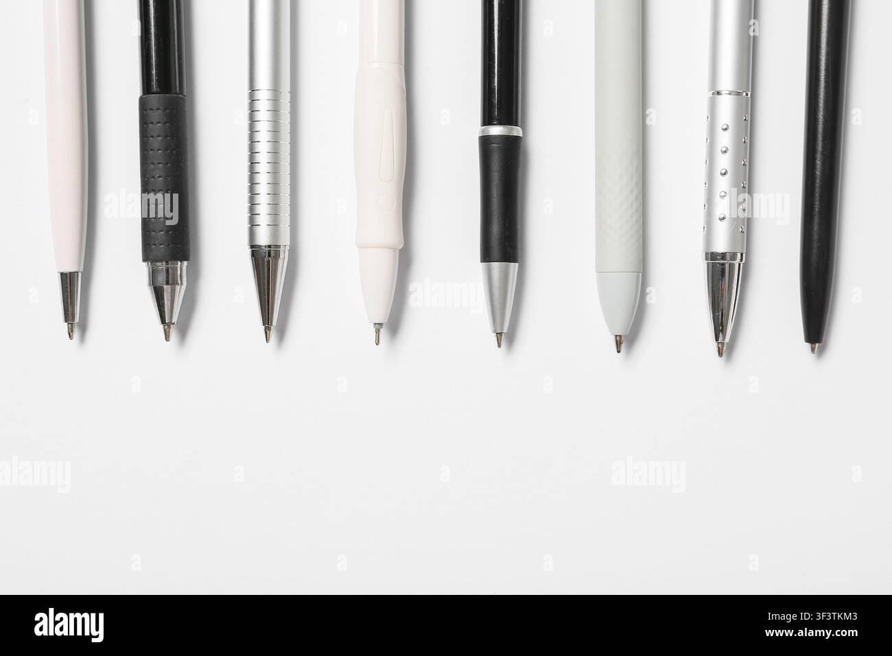 Assortimento di penne a sfera e matite meccaniche nei colori nero, bianco e argento, materiale per ufficio e scuola Foto Stock