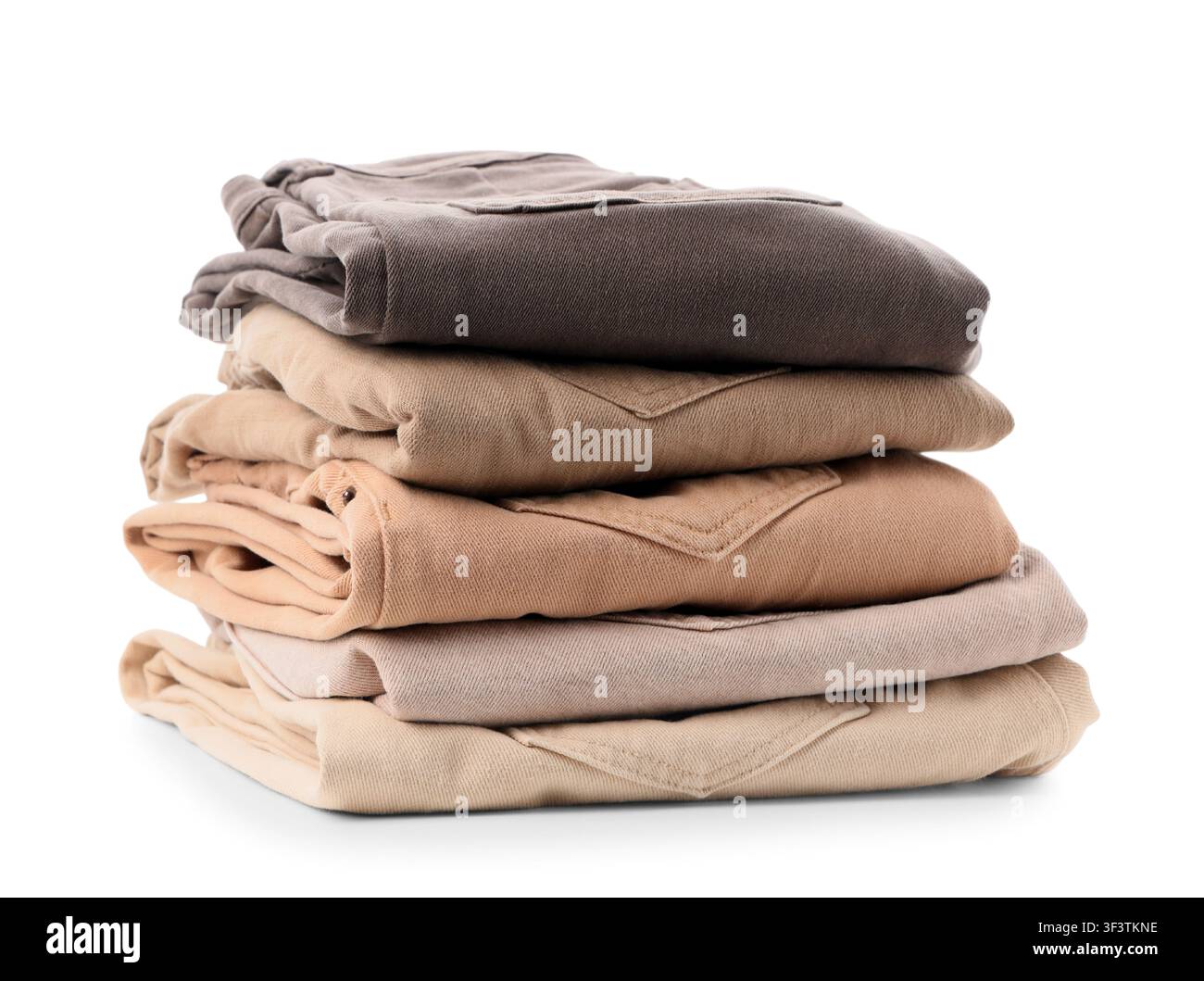 Pila di pantaloni marroni e beige ordinatamente piegati, abbigliamento organizzato per la vendita al dettaglio o per la casa, isolato su uno sfondo bianco Foto Stock