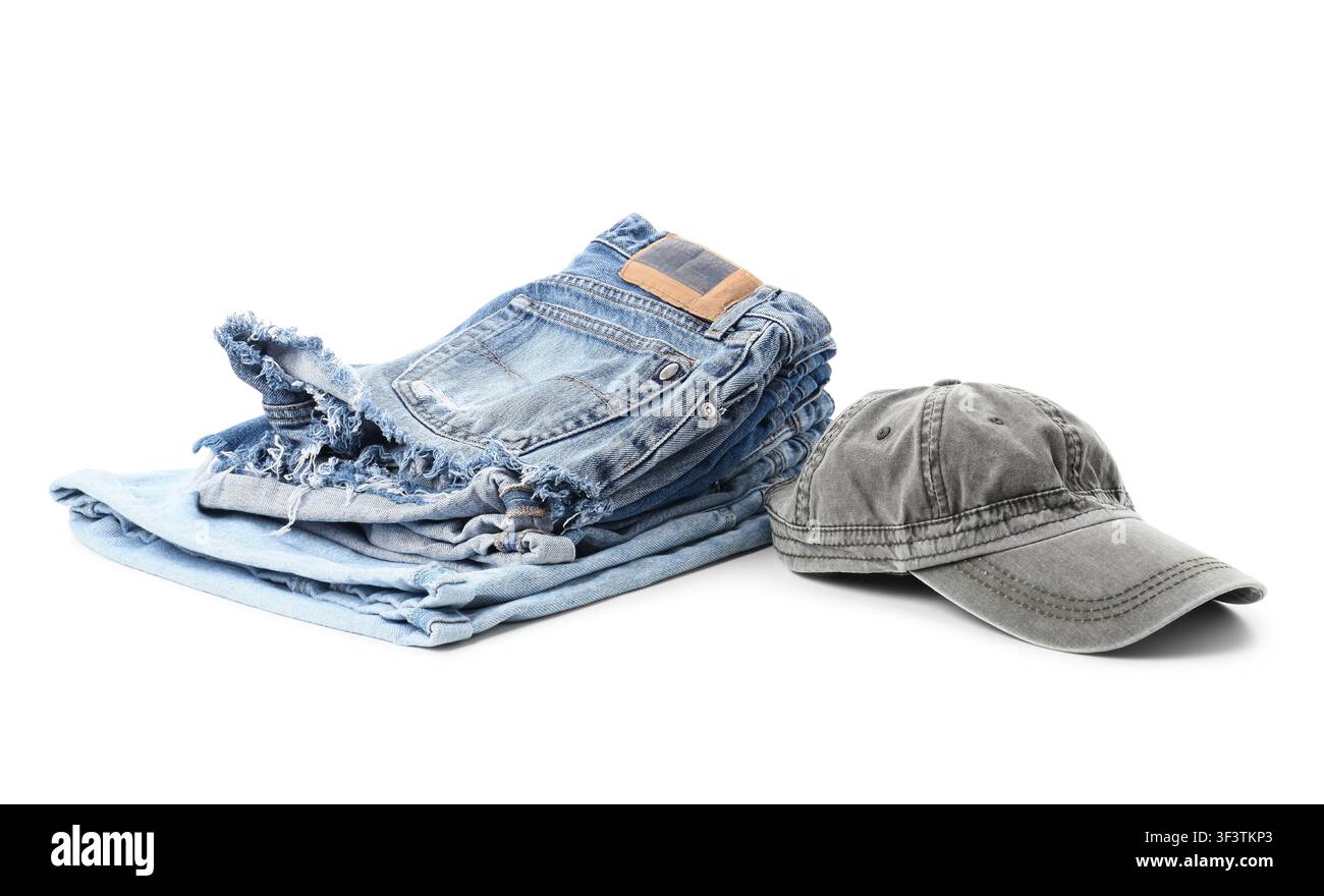 Pila di jeans di denim blu piegati e un cappellino da baseball grigio, moda casual e abbigliamento quotidiano Foto Stock