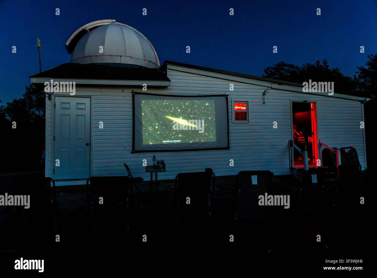 All'Osservatorio Deep Sky Eye su Frotten Road nella municipalità di Argyle, Nuova Scozia, Canada, un proiettore proietta l'immagine di una galassia sulla parete esterna dell'edificio a cupola. L'illuminazione rossa nella porta e nelle finestre assicura che la visione notturna dei visitatori non sia compromessa durante lo spettacolo serale. Argyle Municipal, Nuova Scozia, Canada Foto Stock