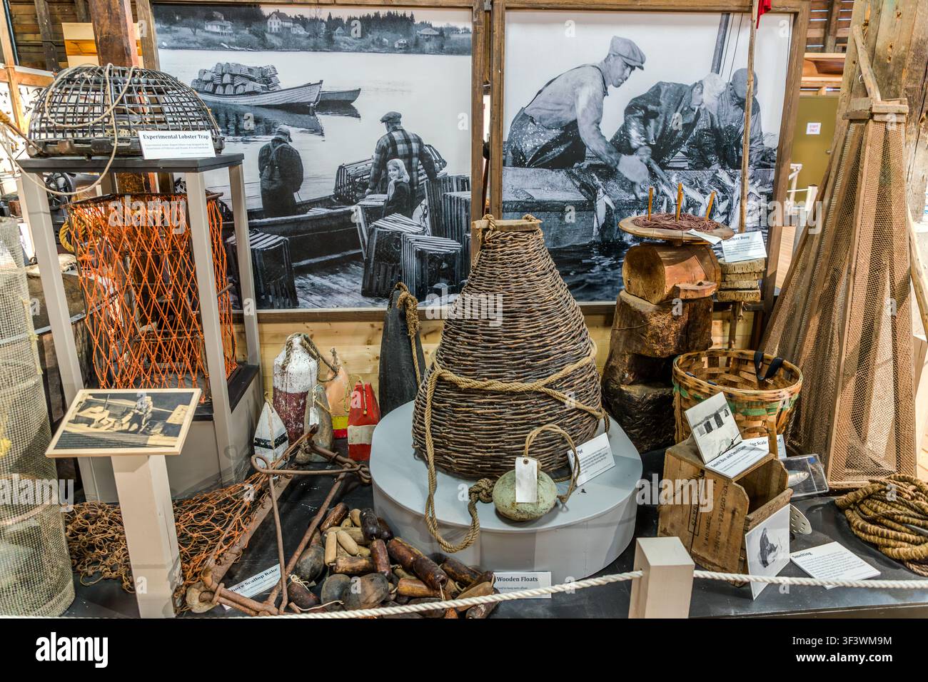 Le trappole per aragoste, le boe di rete e le fotografie storiche in bianco e nero di pescatori esposte al Fisheries Museum of the Atlantic nella vecchia città di Lunenburg, Nuova Scozia, mostrano l’attrezzatura da pesca tradizionale della regione. La mostra documenta l’attrezzatura utilizzata dalle flotte di aragoste e di pesca al largo della costa della Nuova Scozia. Lunenburg, Nuova Scozia, Canada Foto Stock