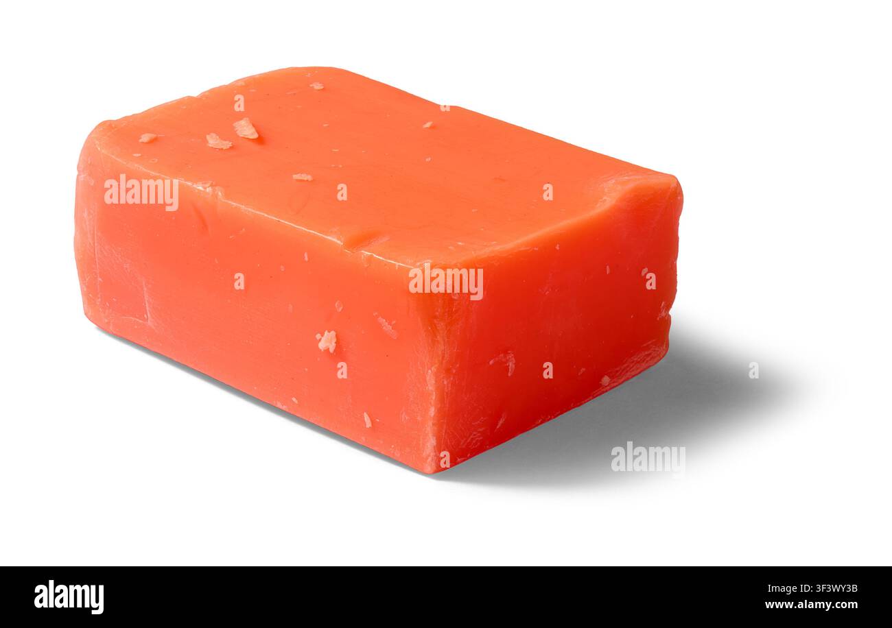 solida saponetta arancione isolata su sfondo bianco, blocco rettangolare di prodotto cosmetico fatto a mano con superficie ruvida Foto Stock