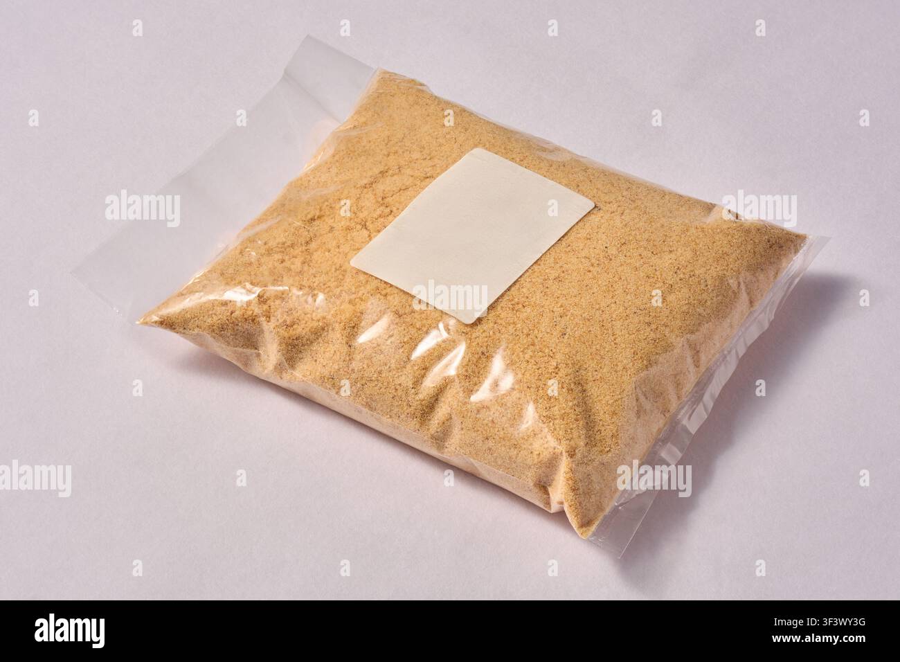Polvere di biscotti in sacchetto di plastica trasparente isolato su sfondo bianco, biscotti schiacciati con etichetta bianca vuota per il branding, modello di mock-up per imballaggio Foto Stock