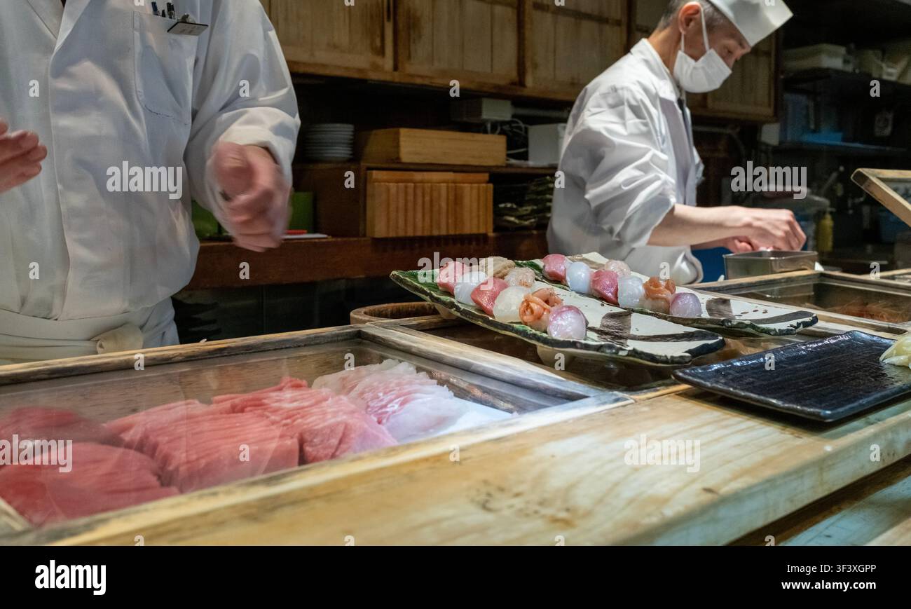 Tokyo – 29 ottobre 2025: Servizio di chef sushi in una bar di sushi nel Mercato Esterno di Tsukiji. Il Mercato Esterno di Tsukiji è un distretto adiacente al sito della forma Foto Stock
