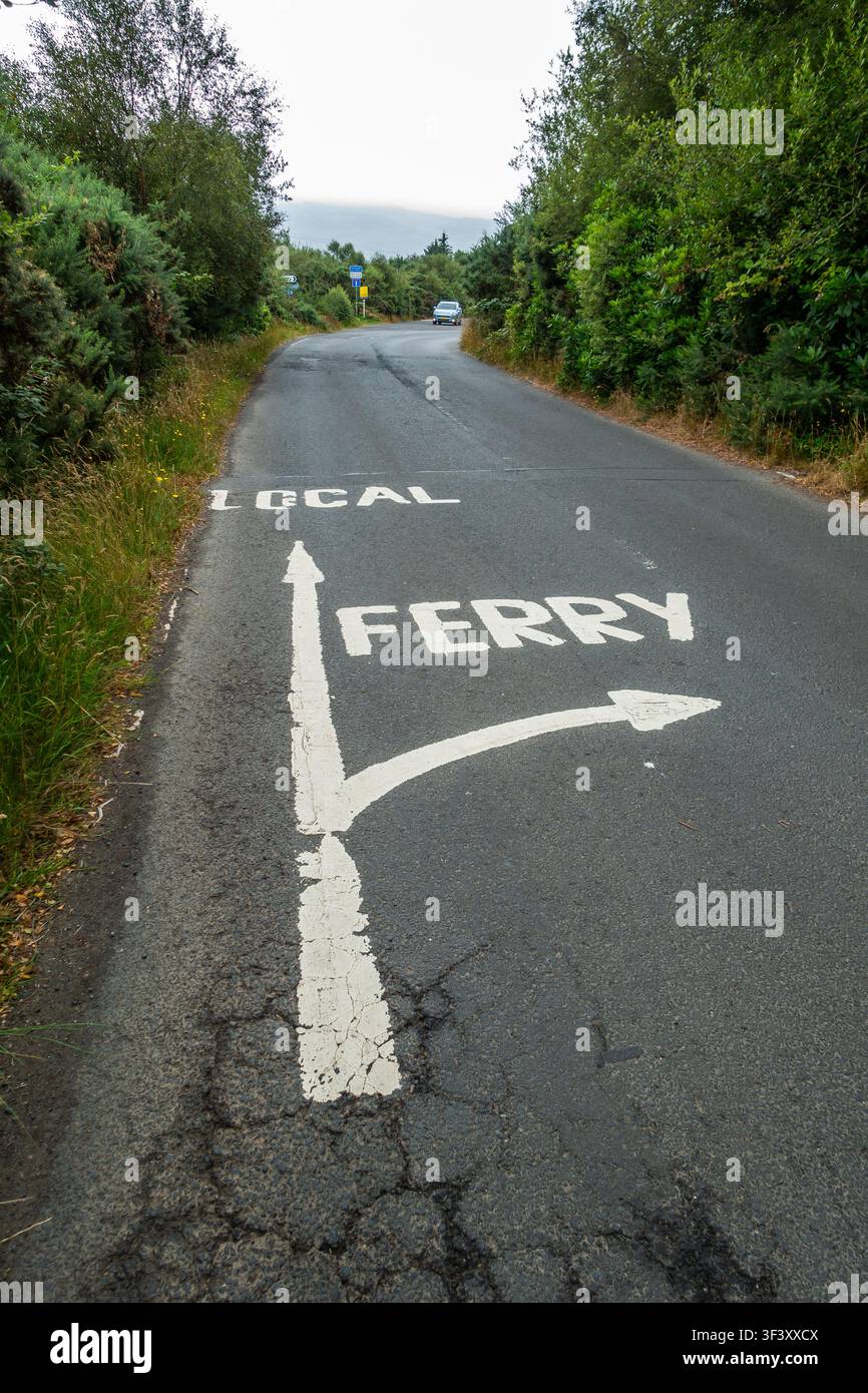 Segnale stradale dipinto che mostra la strada locale e la strada per il traghetto, Scozia Foto Stock