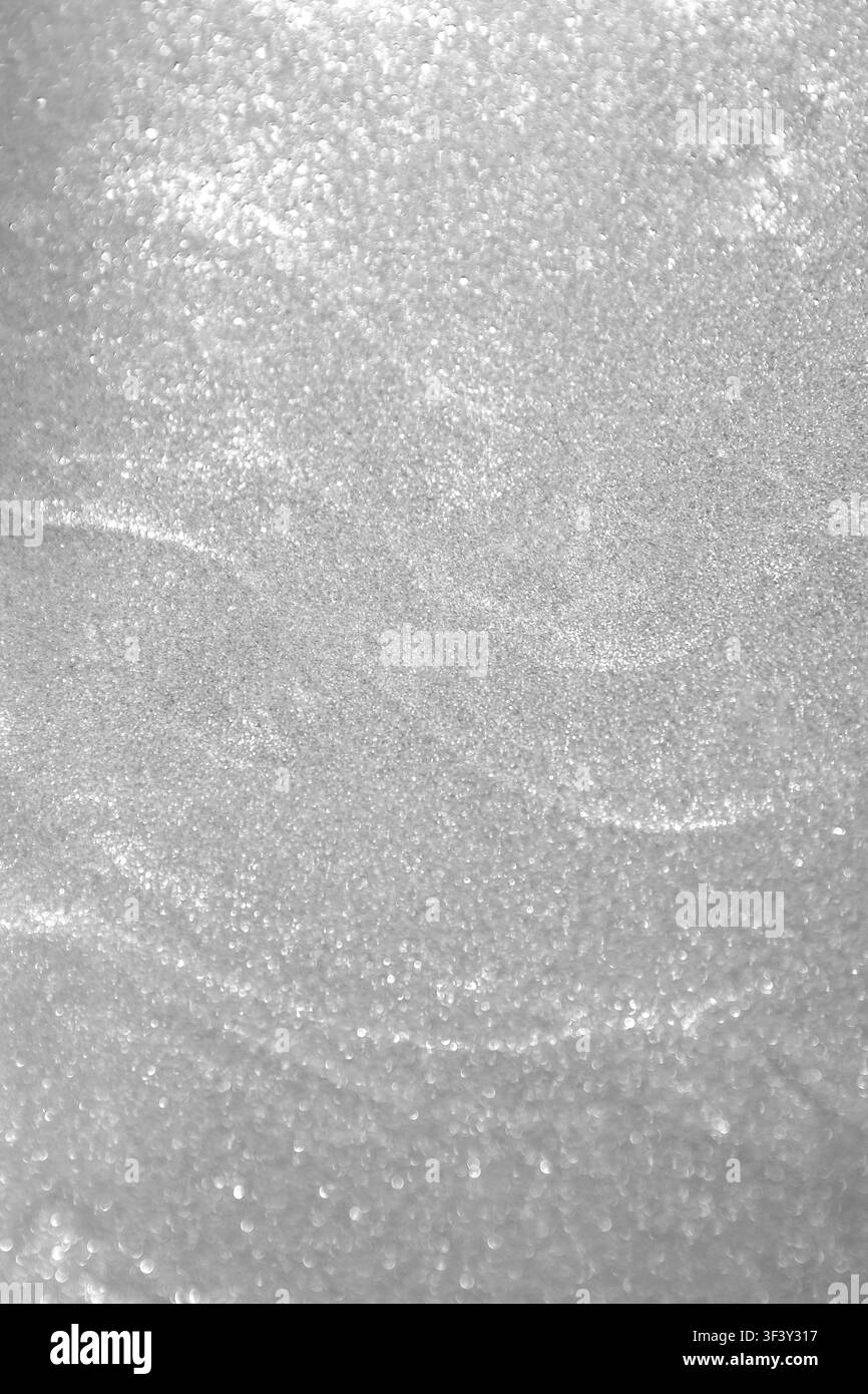 Texture di neve scintillante argentata con sfondo scintillante bokeh per disegni invernali e festivi Foto Stock